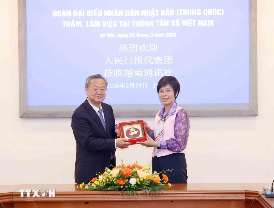 Tổng Giám đốc Thông tấn xã Việt Nam Vũ Việt Trang trao quà lưu niệm cho đồng chí Trần Kiến Văn, Ủy viên Dự khuyết Trung ương Đảng, Tổng Biên tập Nhân dân nhật báo (Trung Quốc). Ảnh: Phương Hoa
