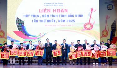 Đại diện Ban tổ chức trao cờ lưu niệm cho các đoàn tham gia Liên hoan.