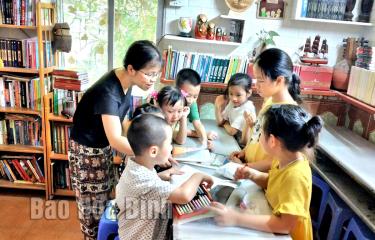 Ảnh: Chị Hồng Nhung cùng các bạn nhỏ tại thư viện